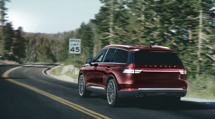 A 2024 Lincoln Aviator® SUV is being driven on a winding mountain road | Kindle Lincoln in Cape May Court House NJ